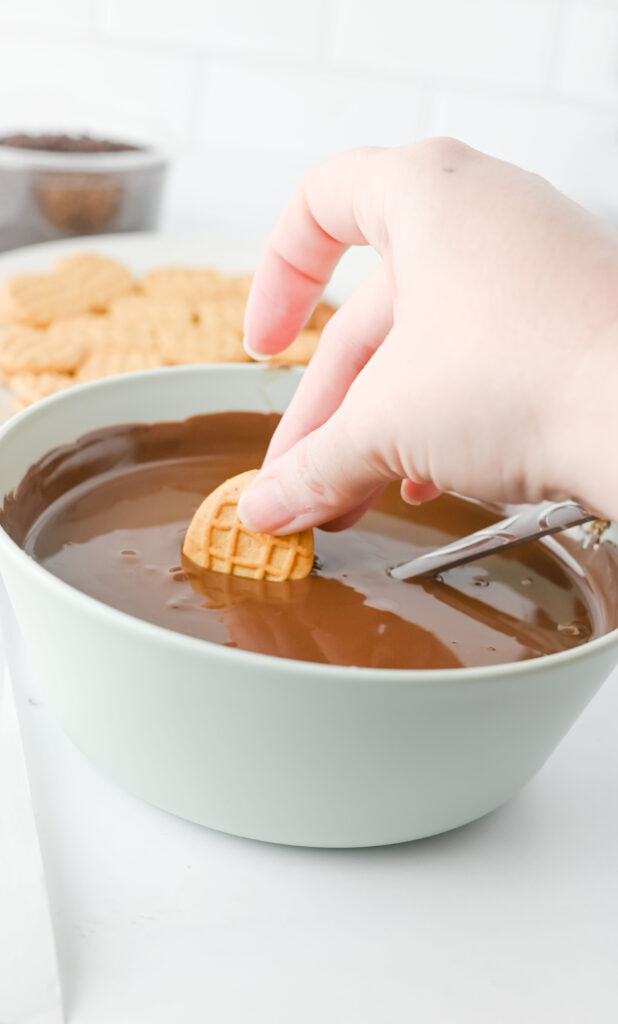 Nutter Butter Acorns - Cultivating Brilliant Minds dipping nutter butter into melted chocolate