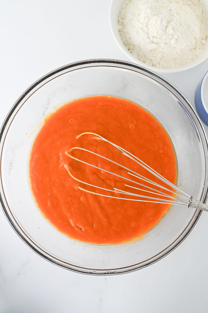 Pumpkin Chocolate Chip Muffins - Cultivating Brilliant Minds muffin batter in a bowl with a whisk