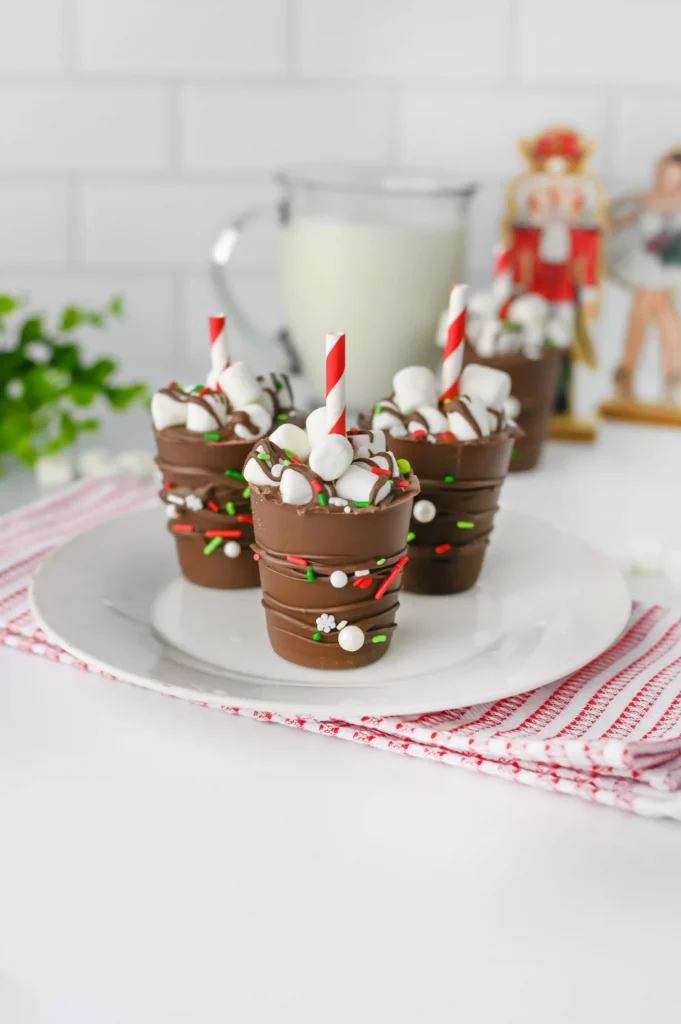 Hot Chocolate Sticks - Cultivating Brilliant Minds hot chocolate sticks with sprinkles and a red and white striped straw on a white plate