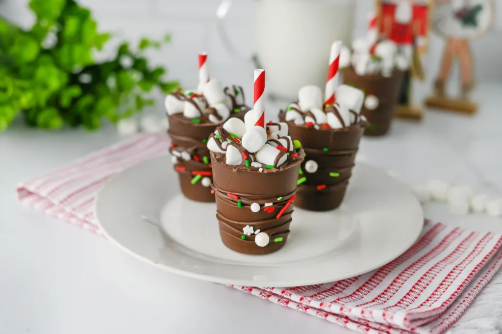 Hot Chocolate Sticks - Cultivating Brilliant Minds hot chocolate sticks with sprinkles and a red and white striped straw on a white plate