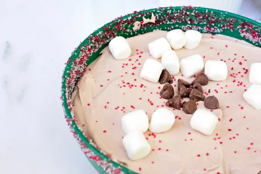 Hot Cocoa Dip - Cultivating Brilliant Minds hot cocoa dip with crushed oreos and marshmallows in a green bowl