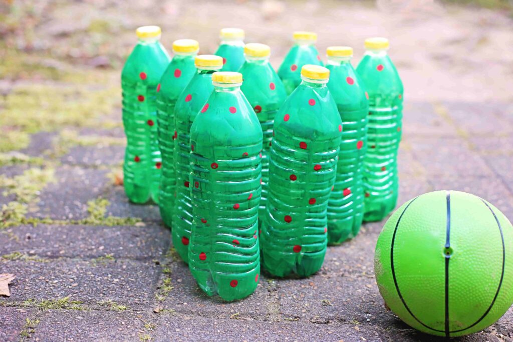 Christmas Tree Bowling - Cultivating Brilliant Minds water bottles painted to look like christmas trees set up like bowling pins
