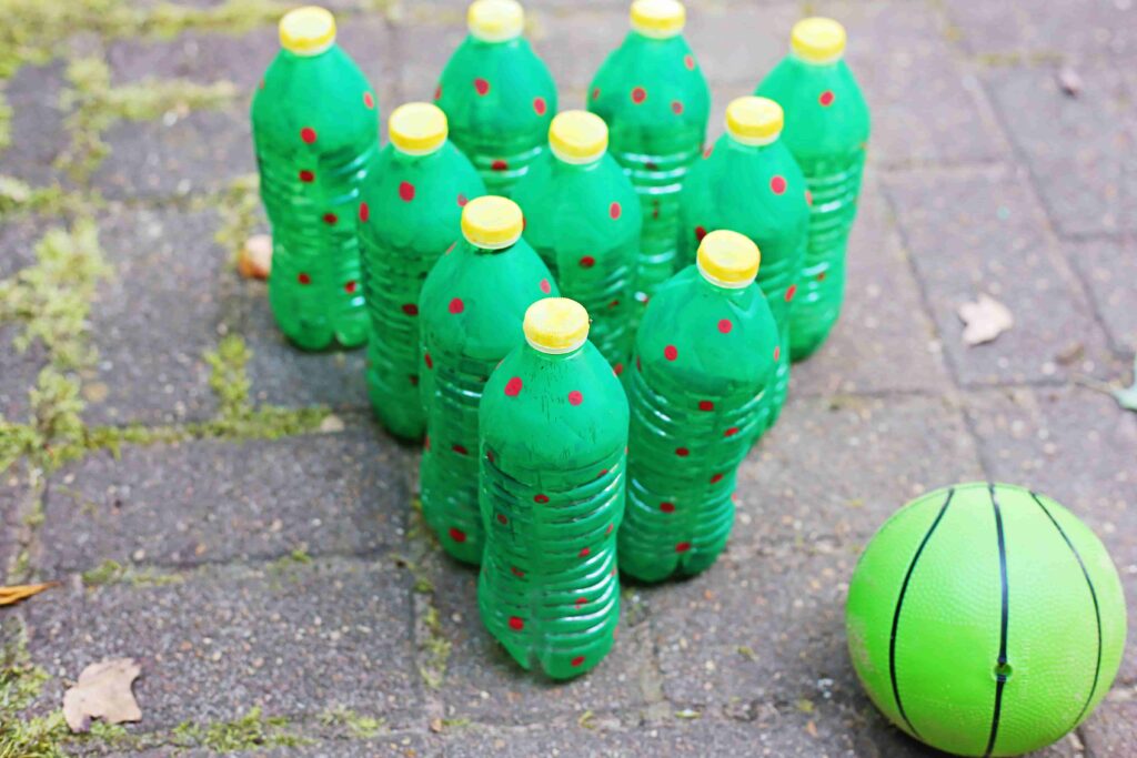 Christmas Tree Bowling - Cultivating Brilliant Minds water bottles painted to look like christmas trees set up like bowling pins