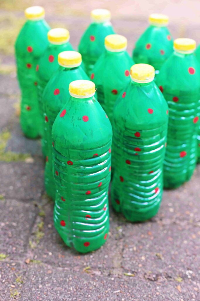 Christmas Tree Bowling - Cultivating Brilliant Minds water bottles painted to look like christmas trees set up like bowling pins