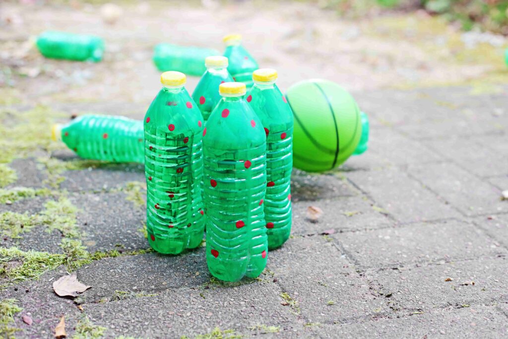Christmas Tree Bowling - Cultivating Brilliant Minds water bottles painted to look like christmas trees set up like bowling pins