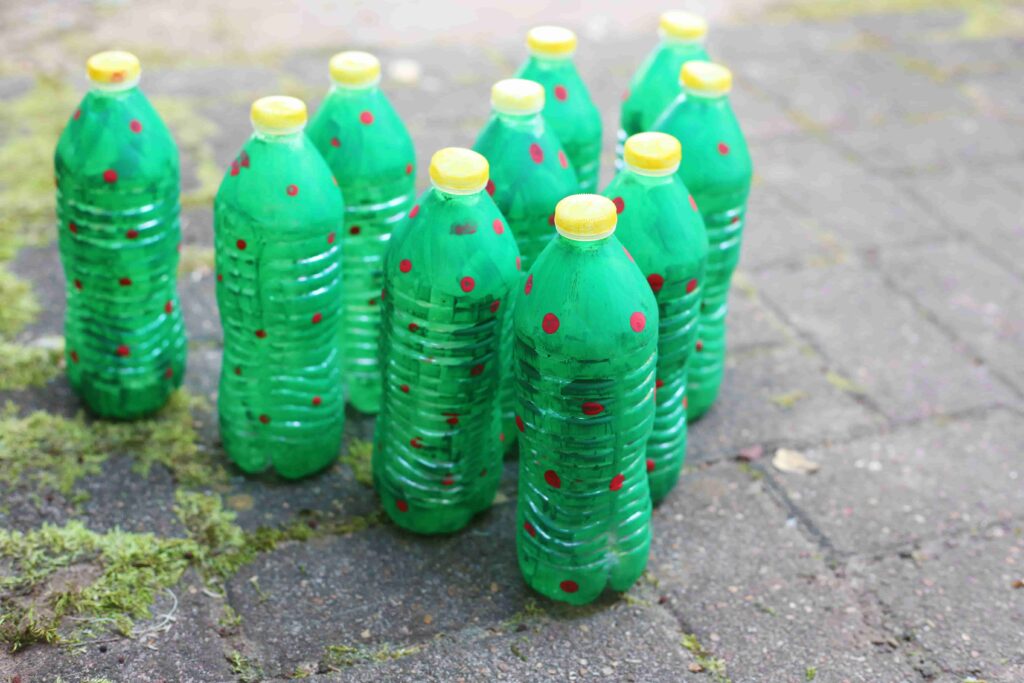 Christmas Tree Bowling - Cultivating Brilliant Minds water bottles painted to look like christmas trees set up like bowling pins