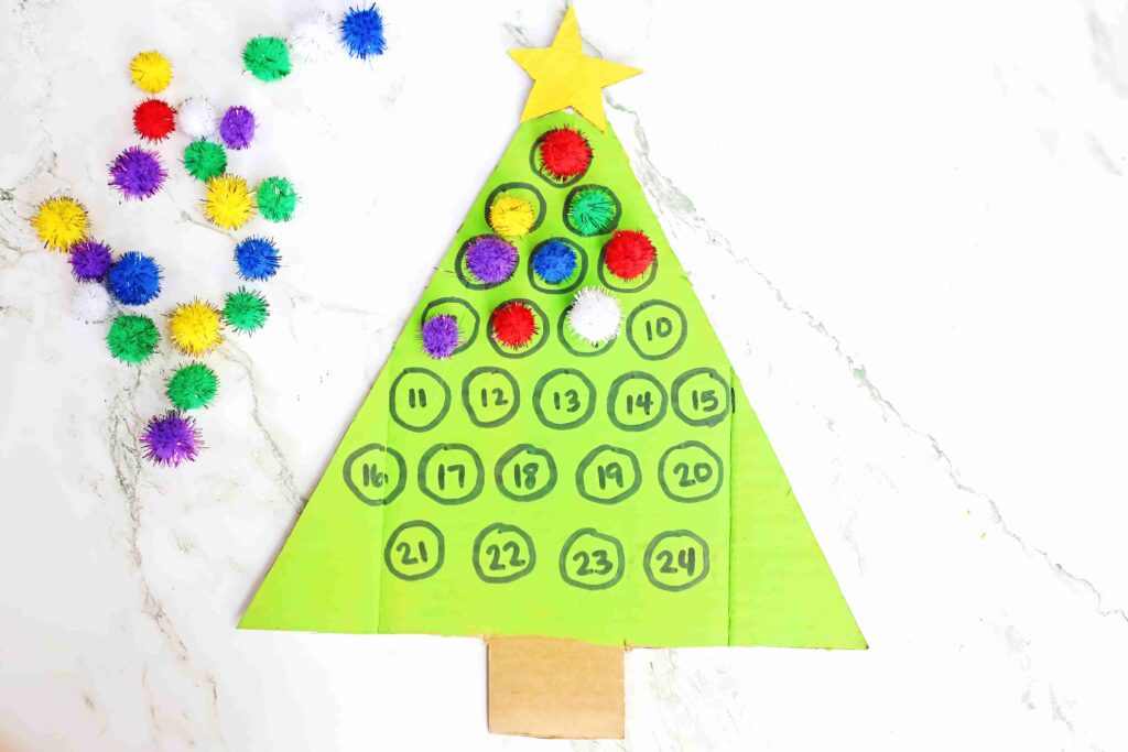 Christmas Tree Countdown Craft - Cultivating Brilliant Minds cardboard painted to look like a christmas tree with numbers on it. Pom poms are glued over some of the numbers