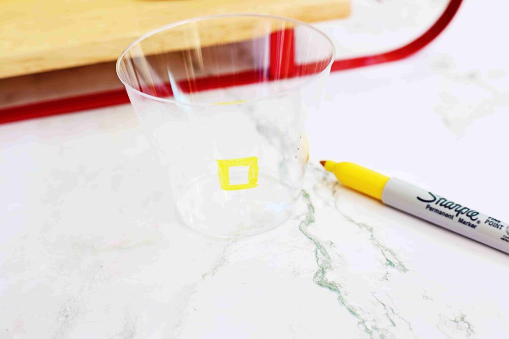 Santa Fruit Cups - Cultivating Brilliant Minds a plastic cup with a yellow belt buckle drawn on