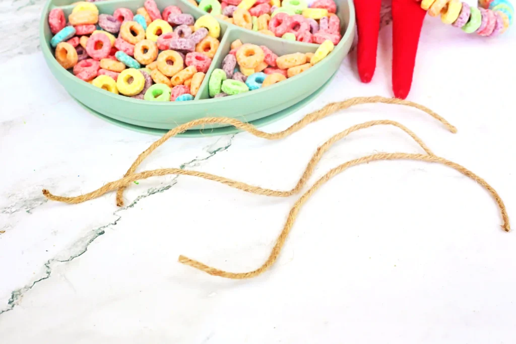 Elf on the Shelf Idea Fruit Loop Bracelets - Cultivating Brilliant Minds sting in front of a bowl of fruit loops