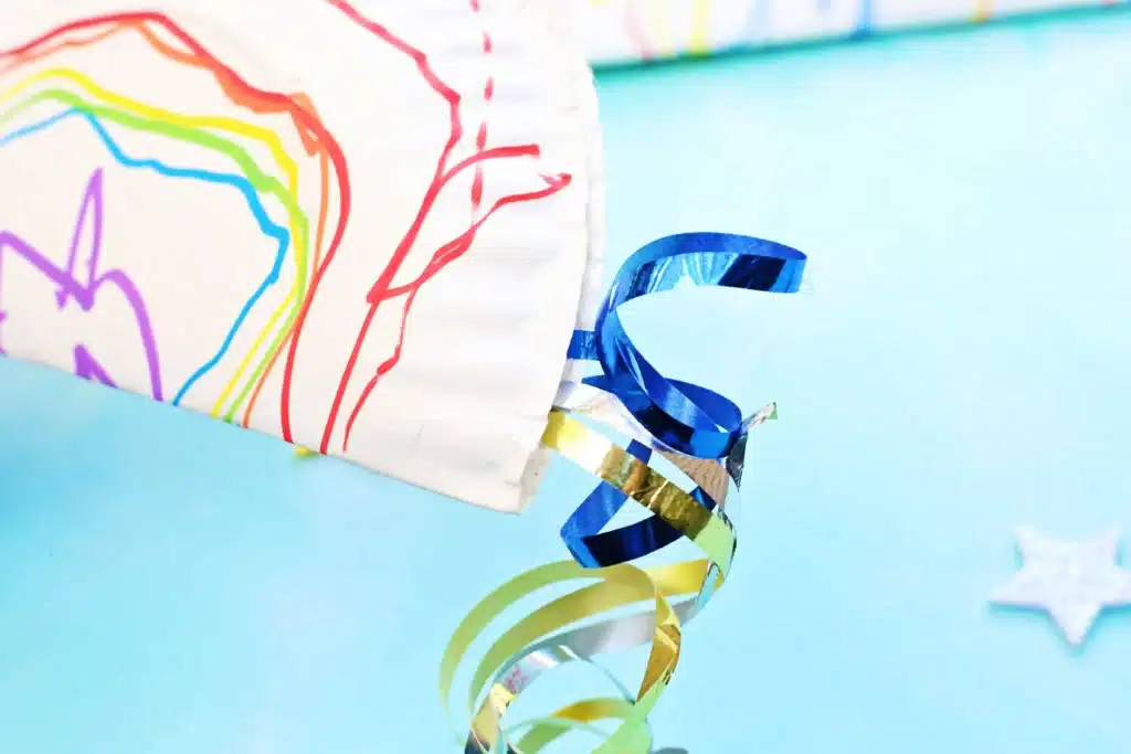 Paper Plate Noisemaker Craft - Cultivating Brilliant Minds a decorated paper plate with curling ribbon on the edges