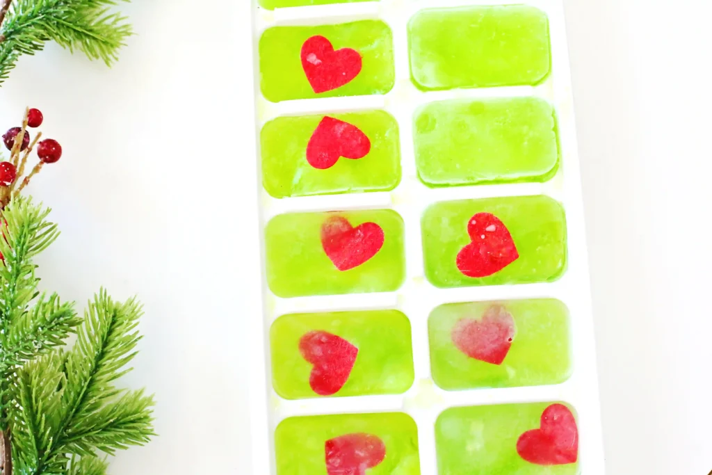 Grinch's Frozen Heart Activity - Cultivating Brilliant Minds ice cubes dyed green with a heart frozen inside