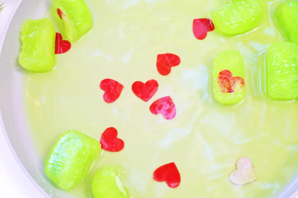 Grinch's Frozen Heart Activity - Cultivating Brilliant Minds melted green ice cubes with red hearts