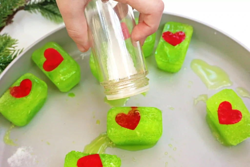 Grinch's Frozen Heart Activity - Cultivating Brilliant Minds ice cubes dyed green with a heart frozen inside