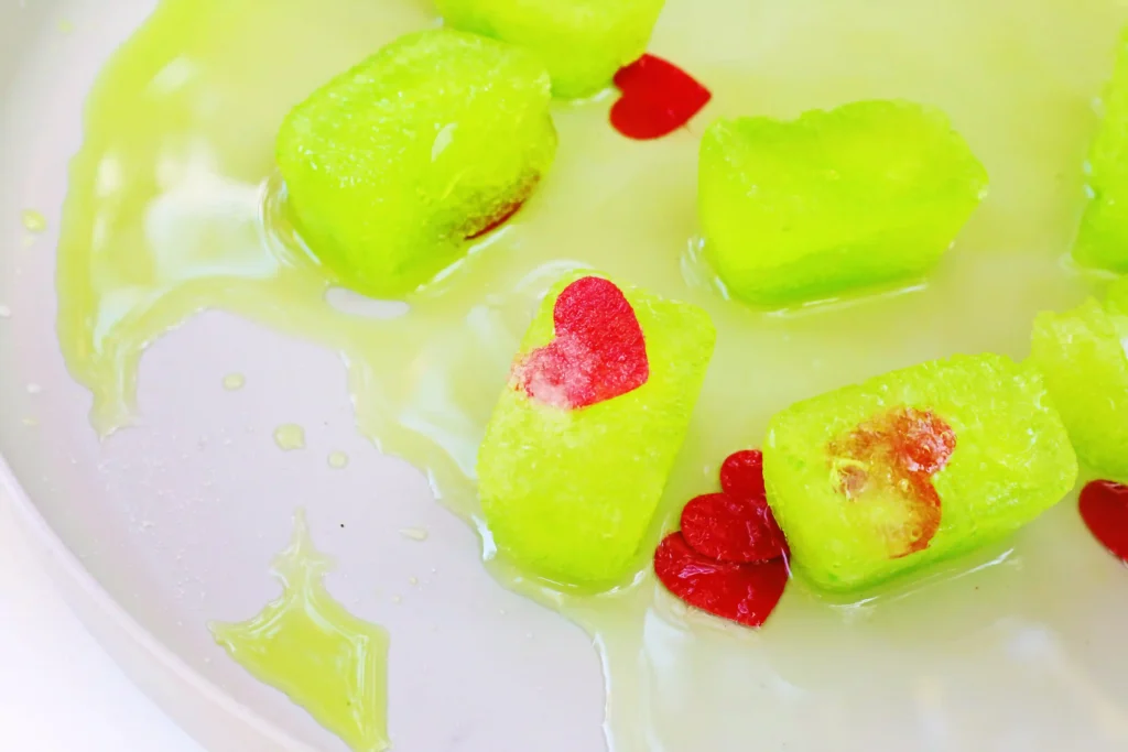 Grinch's Frozen Heart Activity - Cultivating Brilliant Minds melted green ice cubes with red hearts