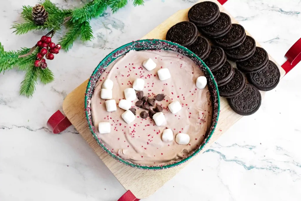 Hot Cocoa Dip - Cultivating Brilliant Minds hot cocoa dip with crushed oreos and marshmallows in a green bowl