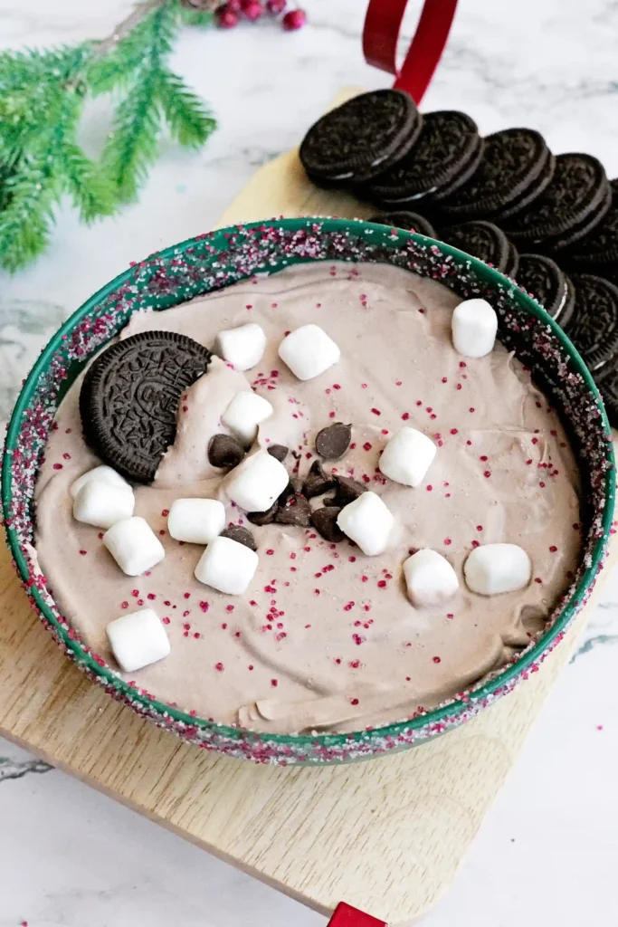 Hot Cocoa Dip - Cultivating Brilliant Minds hot cocoa dip with crushed oreos and marshmallows in a green bowl