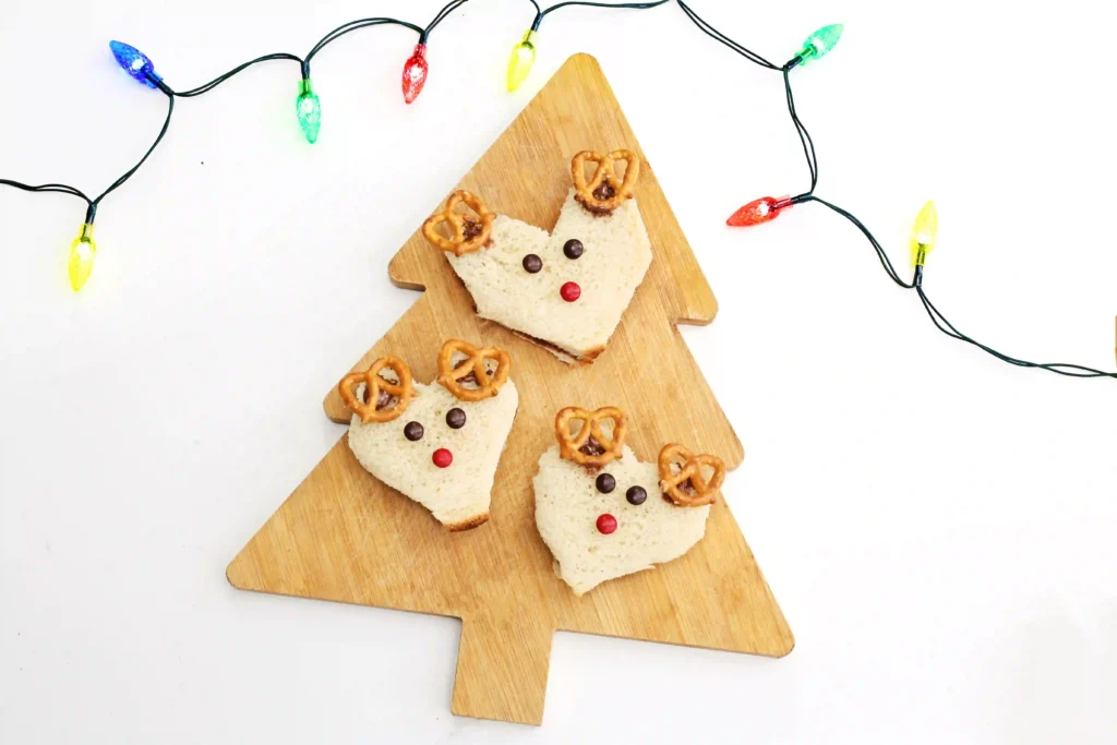 Nutella Reindeer Sandwiches - Cultivating Brilliant Minds a nutella sandwich decorated with m&ms and pretzels to look like a reindeer