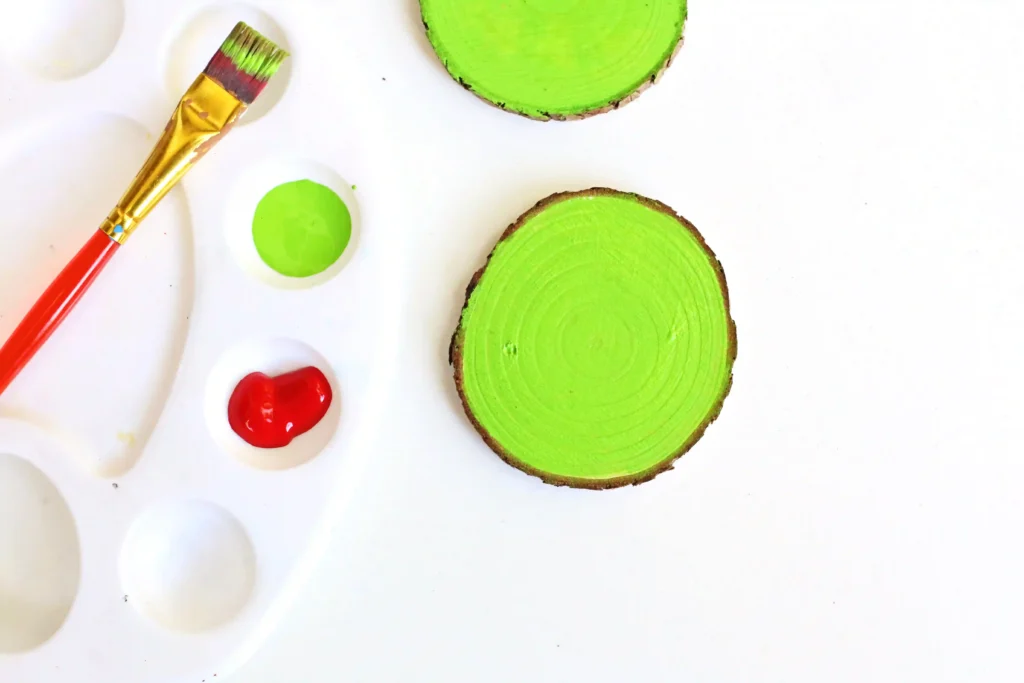 Grinch Heart Wood Slice Ornament Craft - Cultivating Brilliant Minds a wood slice painted green
