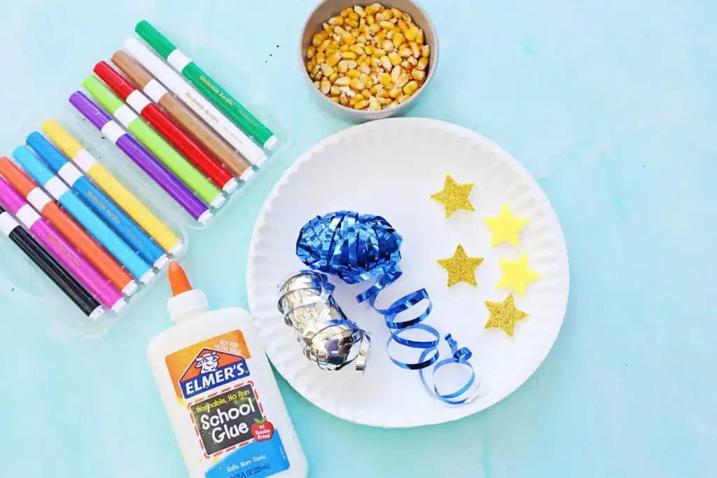 Paper Plate Noisemaker Craft - Cultivating Brilliant Minds paper plate, glue, markers, corn, string, and stars