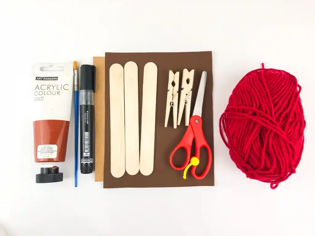 Reindeer Popsicle Stick Ornament Craft - Cultivating Brilliant Minds brown paint, a black marker, paintrbsuh, popsicle sticks, clothespins, scissors, construction paper, and red yarn