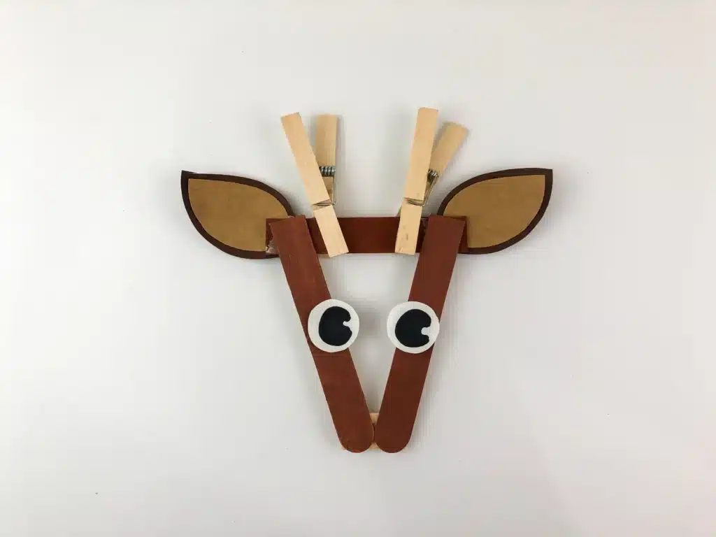 Reindeer Popsicle Stick Ornament Craft - Cultivating Brilliant Minds an ornament craft made of popsicle sticks that looks like a reindeer