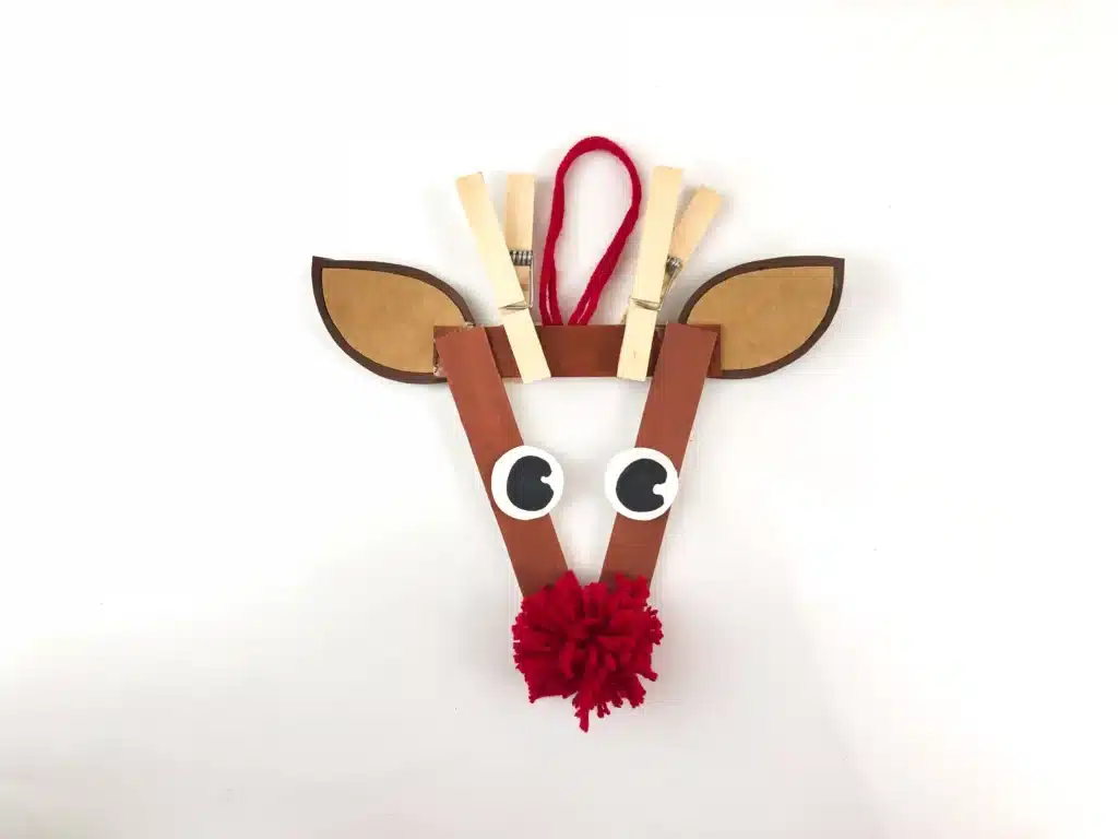 Reindeer Popsicle Stick Ornament Craft - Cultivating Brilliant Minds an ornament craft made of popsicle sticks that looks like a reindeer