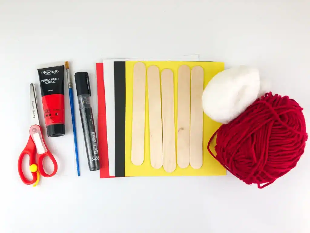 Santa Popsicle Stick Ornament Craft - Cultivating Brilliant Minds scissors, red paint, a paintbrush, a black marker, colored construction paper, popsicle sticks, cotton, and red yarn