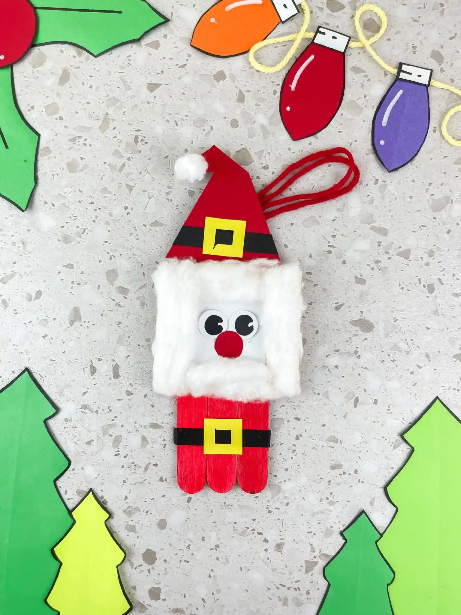 a santa ornament made with popsicle sticks and construction paper