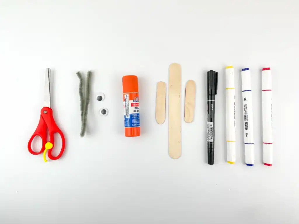 scissors pipe cleaners google eyes glue popsicle sticks black blue red and yellow markers