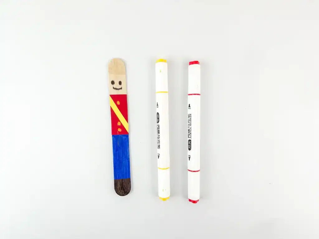 a popsicle stick colored to look like a nutcracker