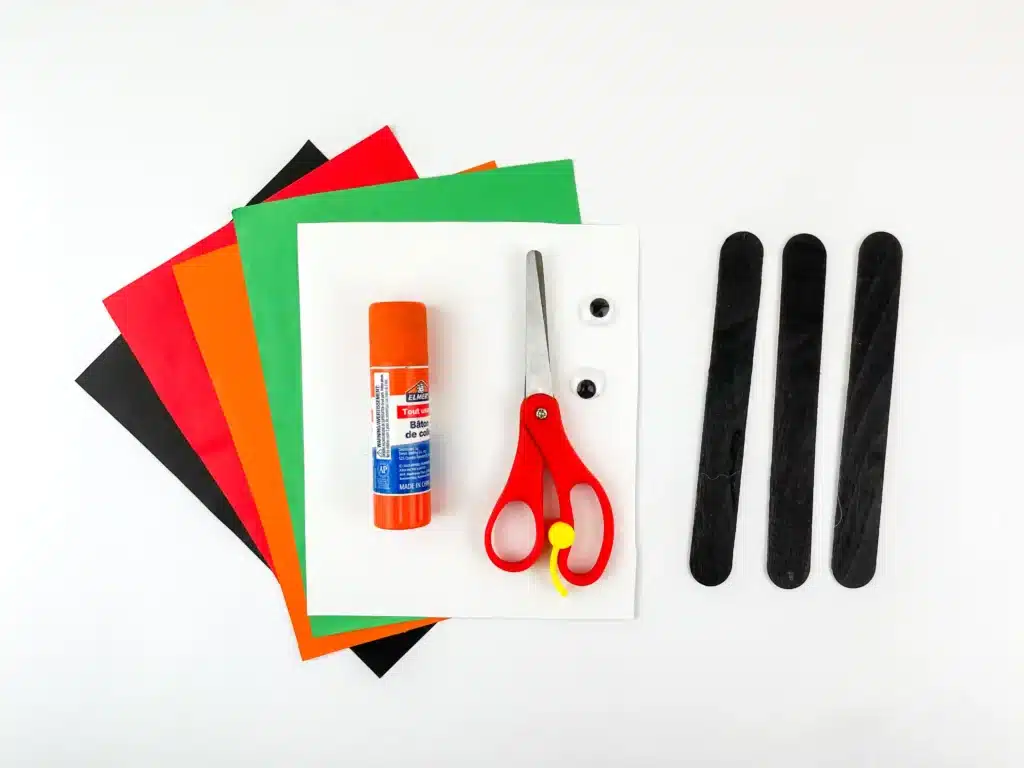 Penguin Ornament Craft - Cultivating Brilliant Minds construction paper, glue, scissors, googly eyes, and popsicle sticks painted black