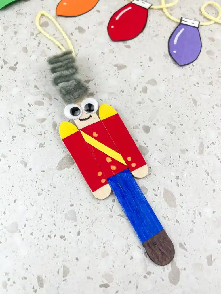 nutcracker ornament craft   popsicle sticks decorated to look like a nutcracker