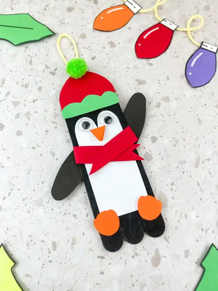 a penguin ornament craft made out of popsicle sticks and construction paper