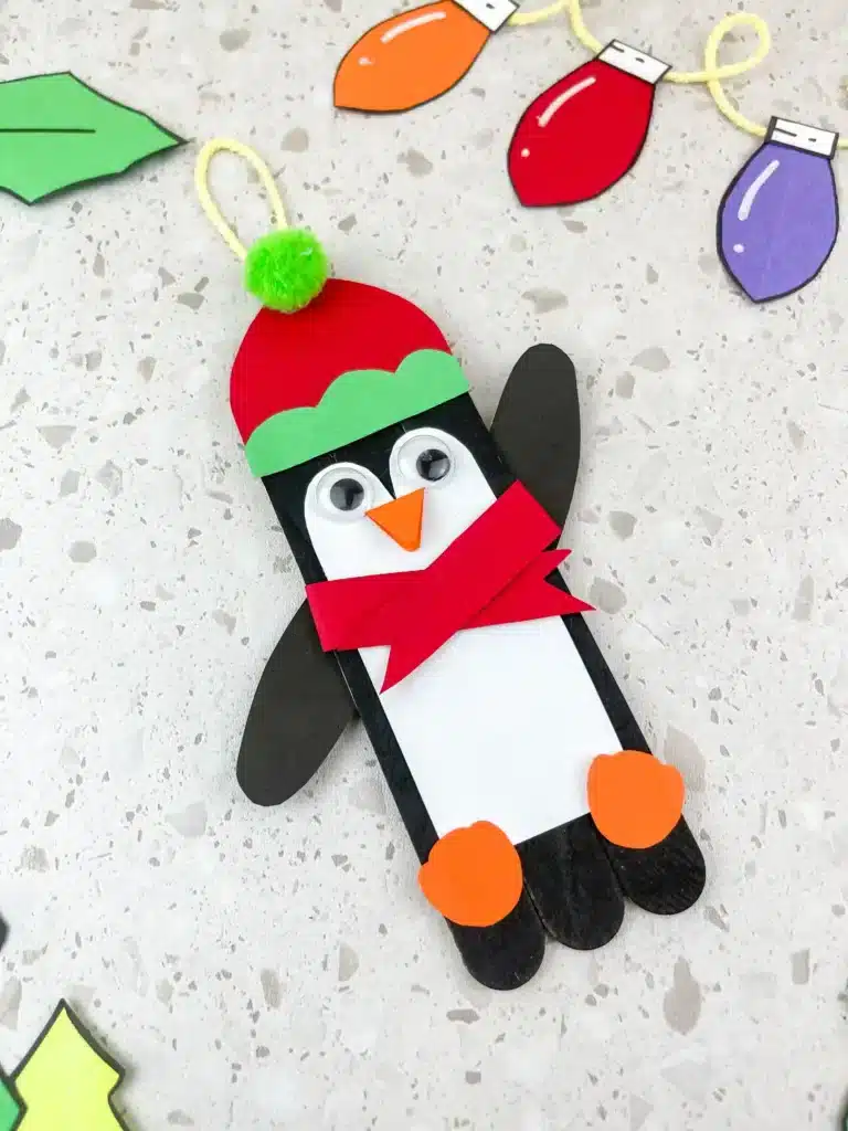 Penguin Ornament Craft - Cultivating Brilliant Minds a penguin made out of popsicle sticks and construction paper