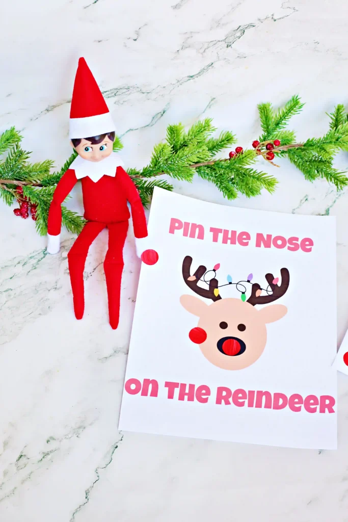Pin the Nose on the Reindeer - Cultivating Brilliant Minds an elf on the shelf next to red dot stickers and a sign that reads "pin the nose on the reindeer"