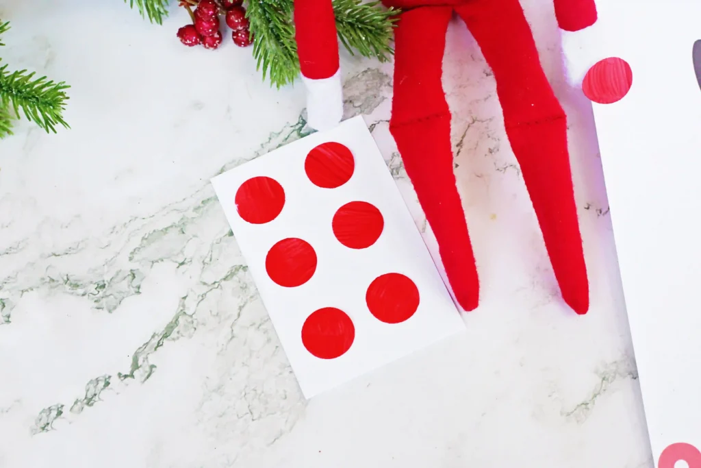 Pin the Nose on the Reindeer - Cultivating Brilliant Minds an elf on the shelf next to red dot stickers