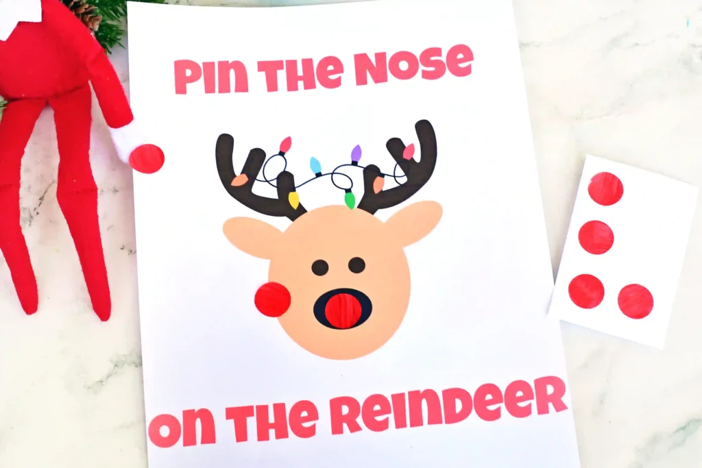 Pin the Nose on the Reindeer - Cultivating Brilliant Minds an elf on the shelf next to red dot stickers and a sign that reads "pin the nose on the reindeer"