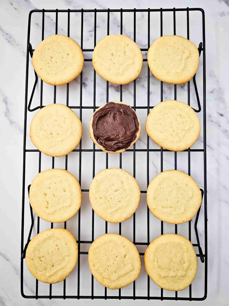 Reindeer Sugar Cookies - Cultivating Brilliant Minds cookies on a cooling rack. one cookie has chocolate icing on it