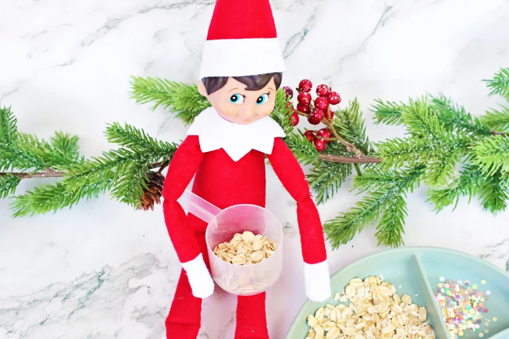 Elf on the Shelf Reindeer Food Craft - Cultivating Brilliant Minds an elf holding a measuring cup with oats in it
