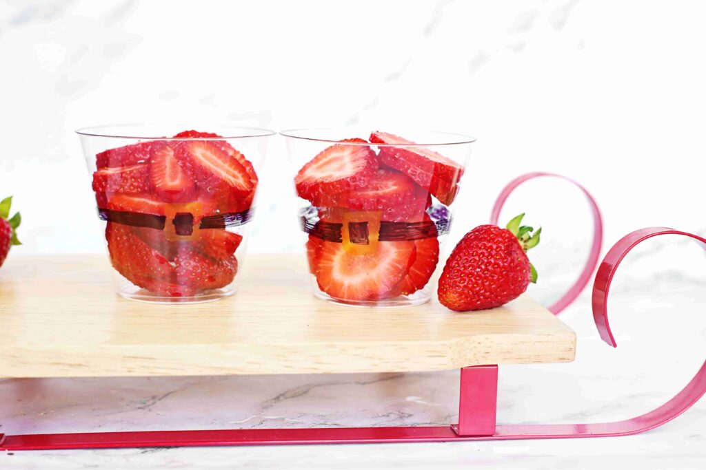 Santa Fruit Cups - Cultivating Brilliant Minds Sliced strawberries in a cup decorated to look like santa's suit