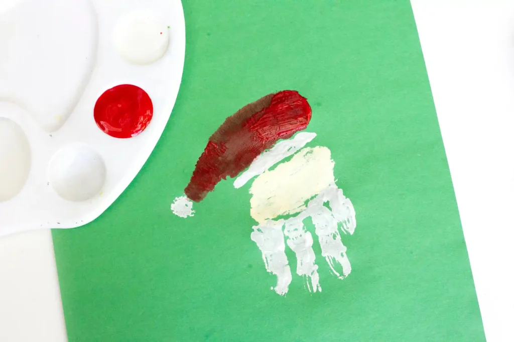 Handprint Santa Ornament - Cultivating Brilliant Minds a handprint on green construction paper