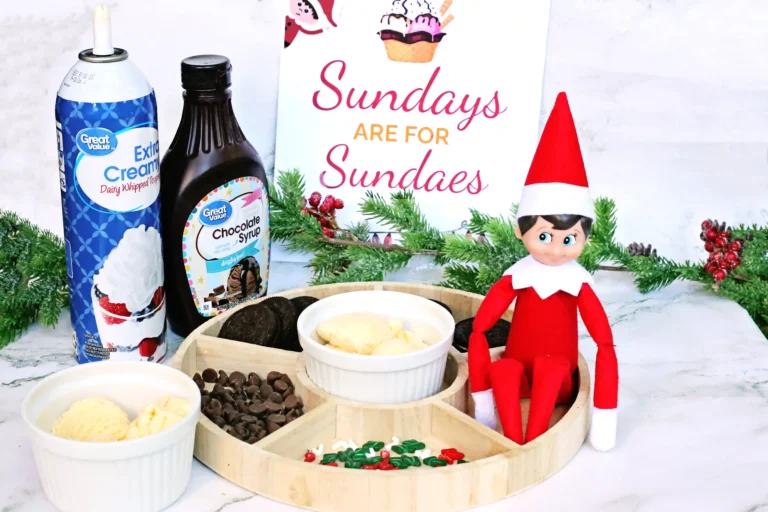 elf on the shelf next to a sundae bar with a sign that reads "sundays are for sundaes"
