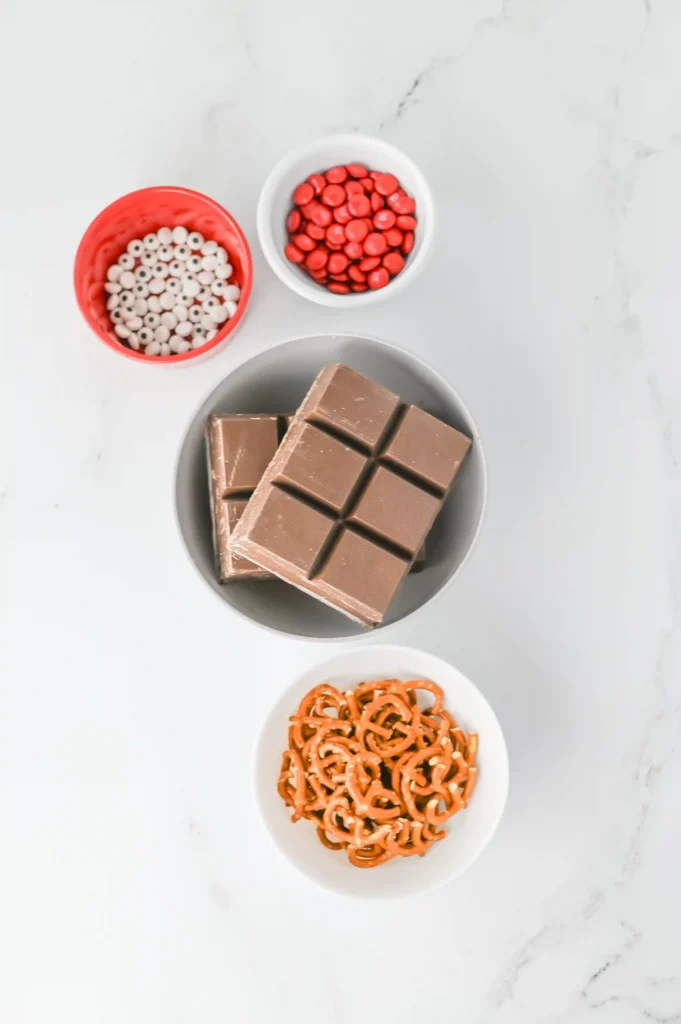 Reindeer Bark for Christmas - Cultivating Brilliant Minds chocolate, candy eyes, red m&m's and pretzels in bowls