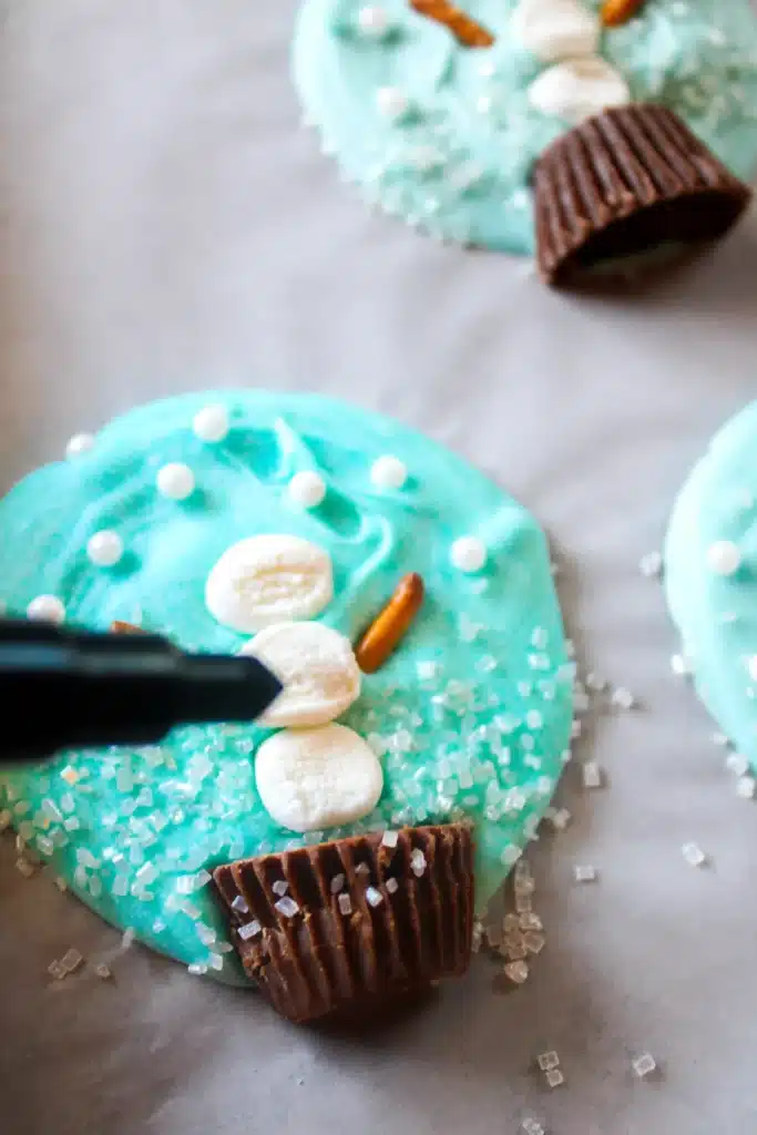 Snowglobe Bark - Cultivating Brilliant Minds an edible pen making buttons on the chocolate snowman