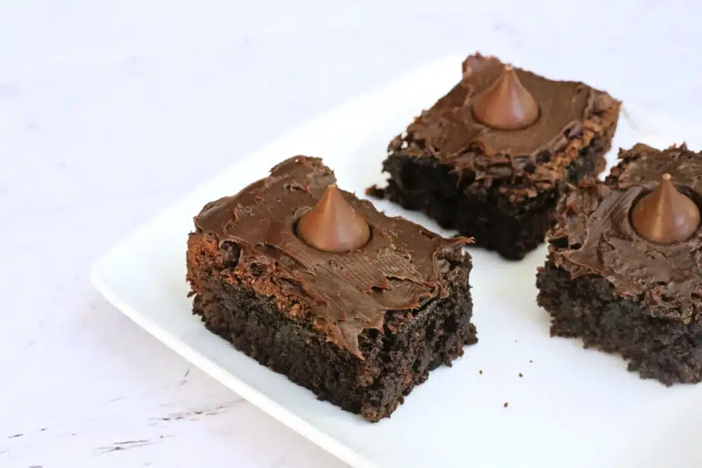 Midnight Kiss Brownies - Cultivating Brilliant Minds brownies with chocolate frosting and a hershey kiss in the middle