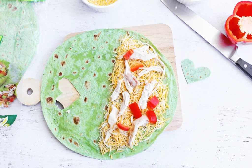 Grinch Quesadillas - Cultivating Brilliant Minds a spinach wrap with cheese, chicken, and red pepper