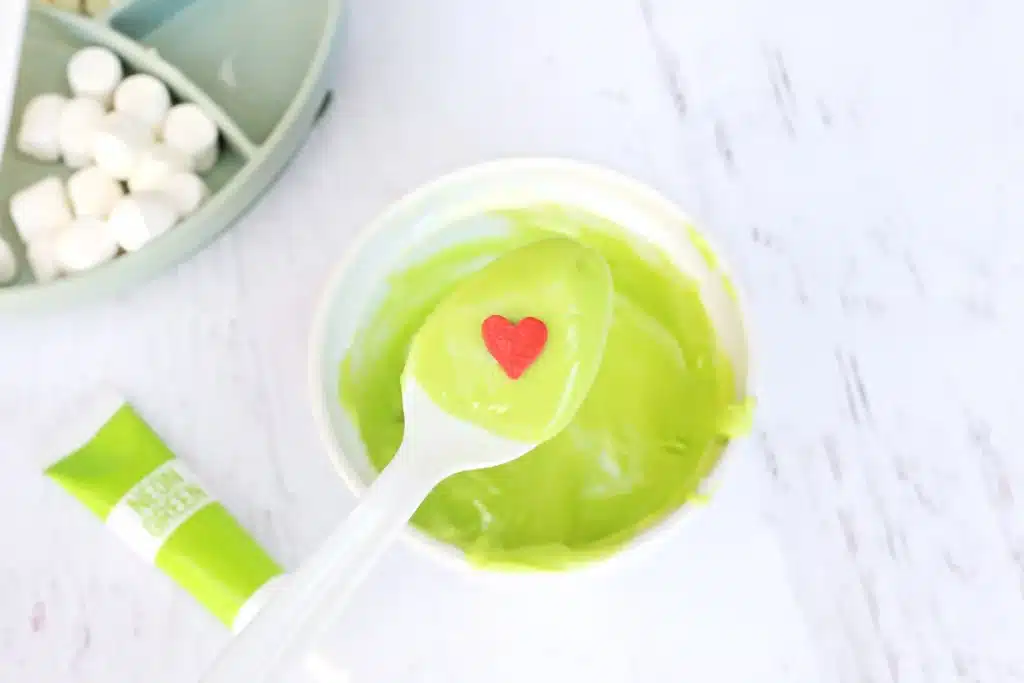 Grinch Hot Chocolate Spoons - Cultivating Brilliant Minds a spoon dipped in melted white chocolate dyed with green food coloring