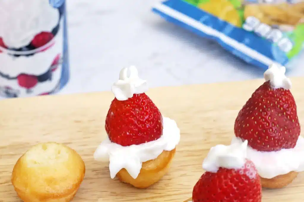 Santa Hat Muffins - Cultivating Brilliant Minds muffins with whipped cream and a strawberry to look like a santa hat