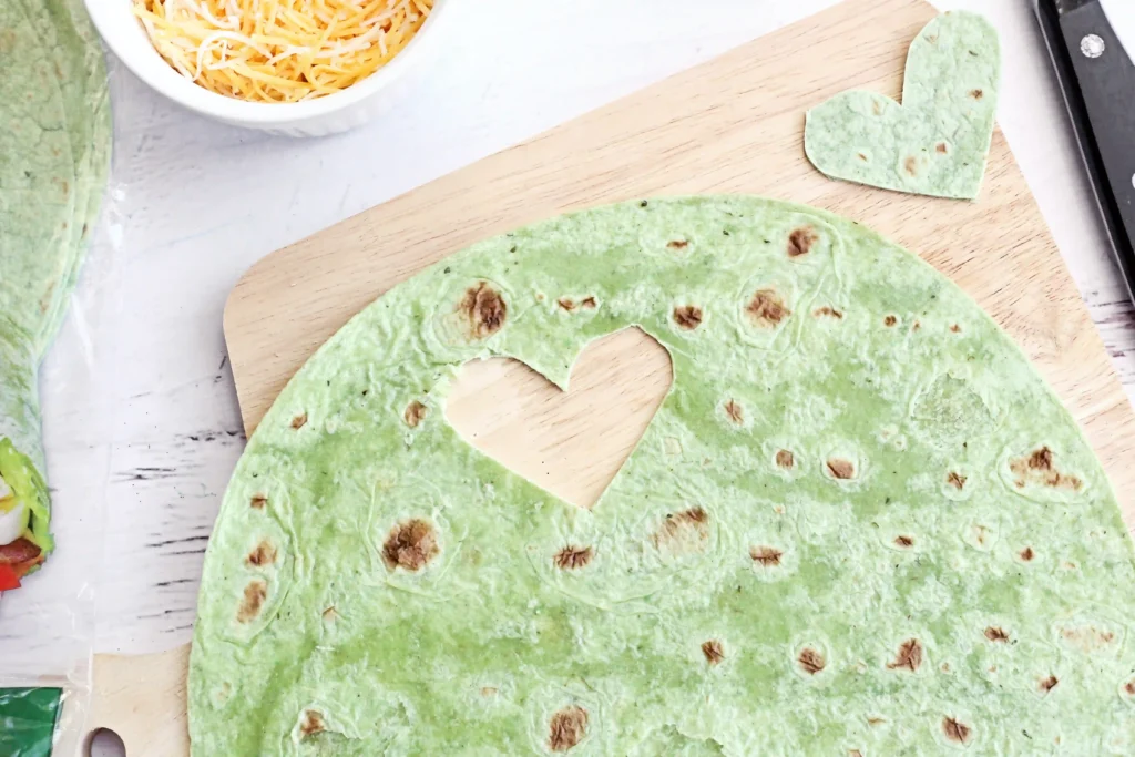Grinch Quesadillas - Cultivating Brilliant Minds a spinach wrap with a heart cut out