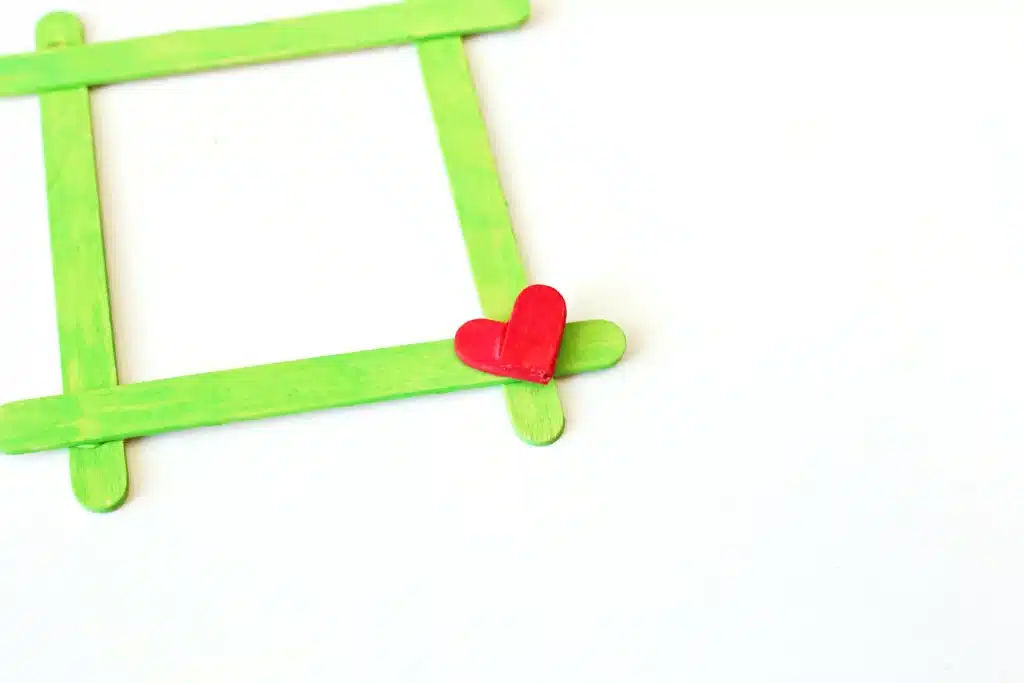 Grinch Popsicle Stick Photo Frame - Cultivating Brilliant Minds a grinch popsicle stick frame painted green with a red heart